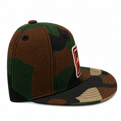 A structured flat-brim cap in a classic woodland camouflage pattern of green, brown, black, and tan. It features a black button on top, ventilation eyelets, and a stylized orange and white embroidered patch on the side.