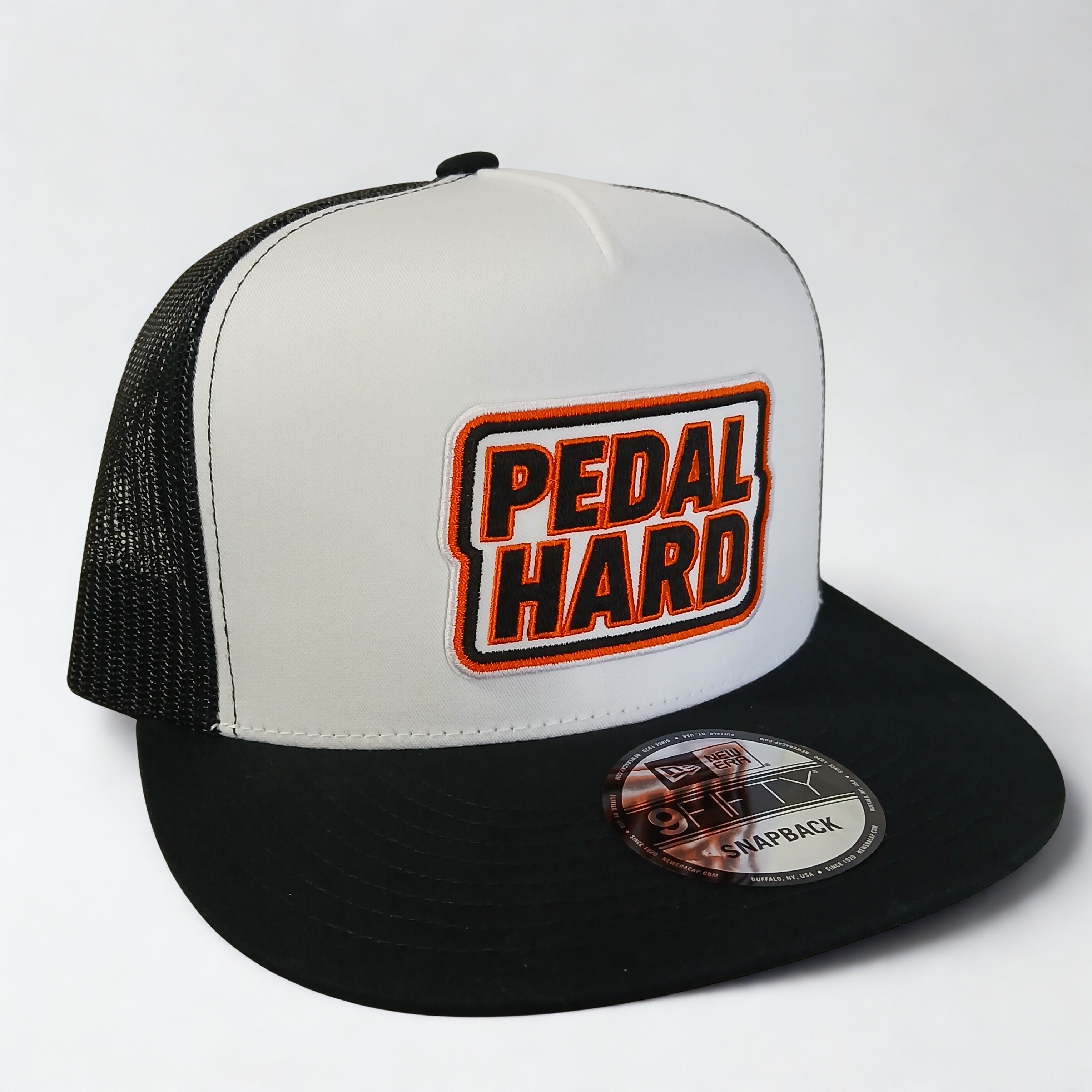 PEDAL HARD Bmore Classic snapback hat front view white front panel with Bmore Orange PEDAL HARD patch black mesh back flat bill cap