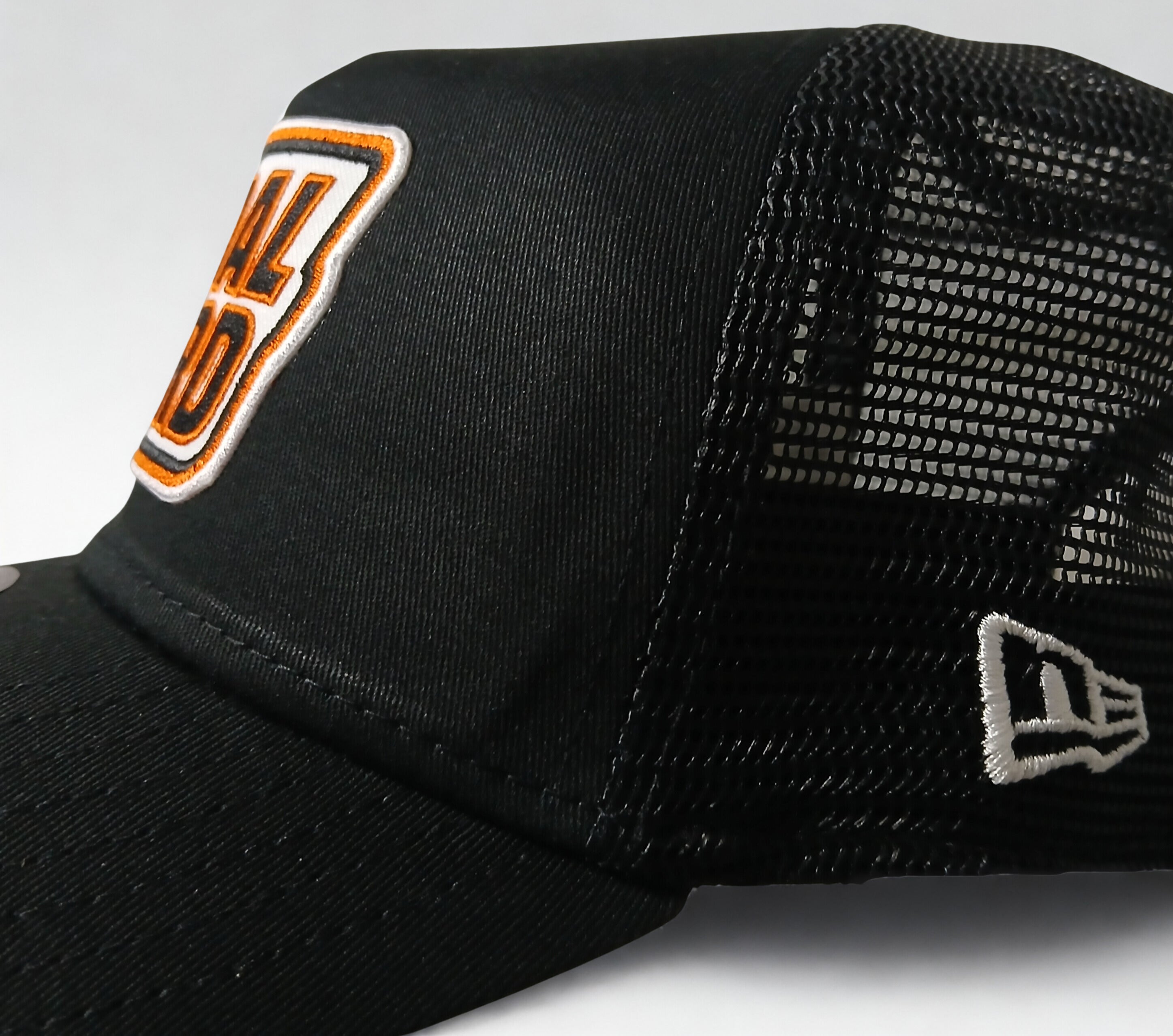 PEDAL HARD Cityline Trucker snapback hat side logo detail showing embroidered PEDAL HARD patch on black trucker hat